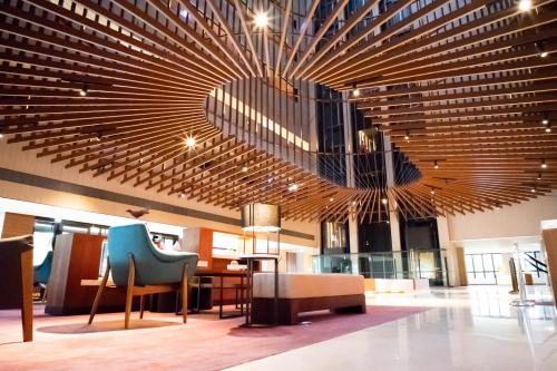 a lobby with a large wooden ceiling with chairs and tables at Crowne Plaza Tainan by IHG in Tainan