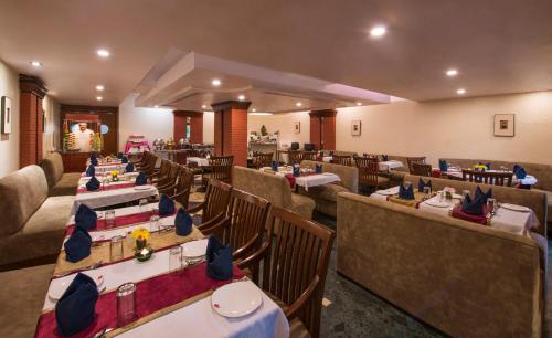 ヴァドーダラーにあるLords Inn Vadodaraの部屋にテーブルと椅子があるレストラン