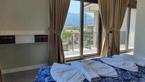 a bedroom with two beds and a large window at Dalyan Villa Carmen-2 in Dalyan