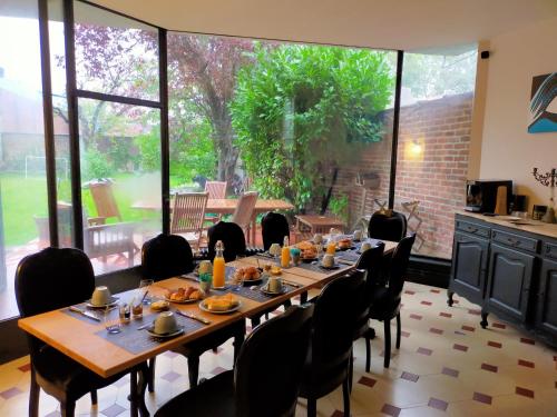 a dining room with a long table and chairs at La Maison Bleue de Roubaix in Roubaix