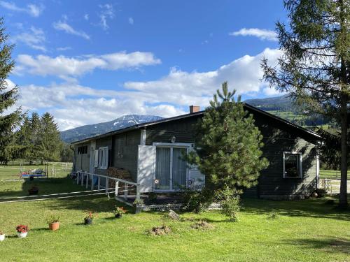 a small house with a tree in front of it at Traumhafte Wohnung auf Pferde Ranch in Aich