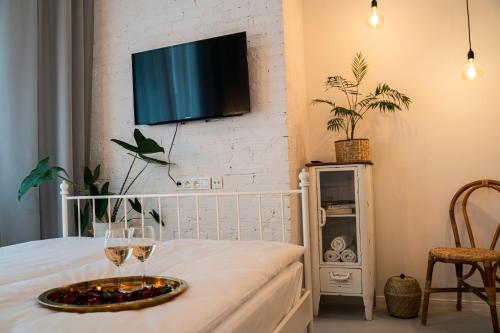 a room with a wine glass and a tv on a wall at Folk by Anne Apartments & Rooms in Warsaw