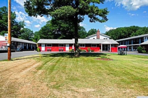a red building with a tree in the middle of a yard at Red Ranch Inn in Catskill