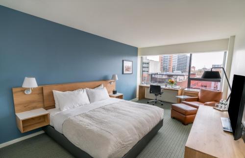 - une chambre avec un grand lit et un mur bleu dans l'établissement The Study at Yale, Study Hotels, à New Haven