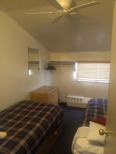 a bedroom with two beds and a ceiling fan at St Moritz Lodge and Condominiums in Aspen
