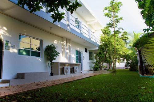 une maison blanche avec une pelouse devant elle dans l'établissement Cozumel 400A - Vacation Rental, à Cozumel