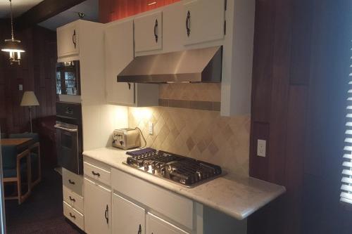 a kitchen with white cabinets and a stove top oven at St Moritz Lodge and Condominiums in Aspen