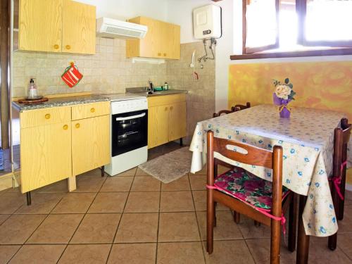 a small kitchen with a table with a table cloth on it at Belvilla by OYO Fienile Regoli Due in Crone