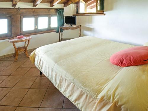 um quarto com uma cama com uma almofada vermelha em Belvilla by OYO Fienile Regoli Due em Crone
