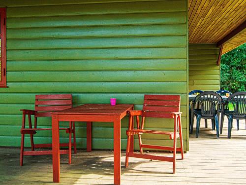 a wooden table and chairs in front of a green wall at 6 person holiday home in Toftlund-By Traum in Arrild