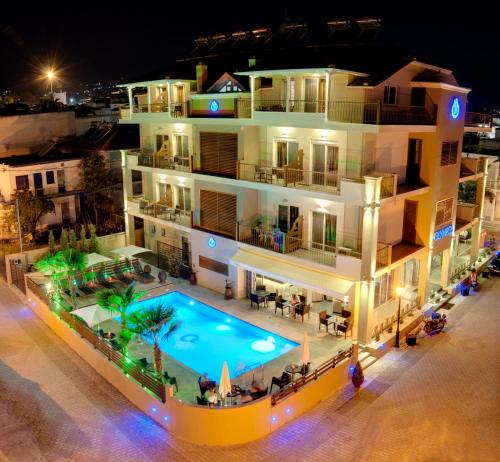 レプトカリヤにあるHotel Olymposの夜間のスイミングプール付きのアパートメントビル