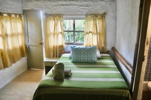 1 dormitorio con 2 camas y ventana en Viejamar B&B en Puerto López