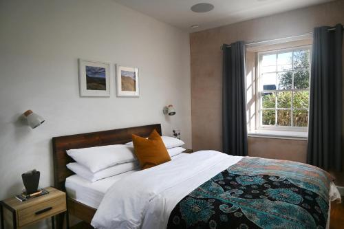 um quarto com uma cama com lençóis brancos e uma janela em The Auld Kirk & Spa em Stirling