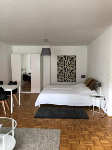 a bedroom with a large white bed and a table at Ferienwohnung in Potsdam Babelsberg Nähe Berlin in Potsdam