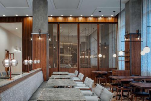 a restaurant with tables and chairs and a row of tables at Hyatt Centric Center City Philadelphia in Philadelphia