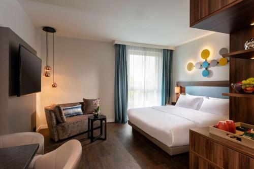 um quarto de hotel com uma cama e uma cadeira em Hyatt House Frankfurt Eschborn em Eschborn