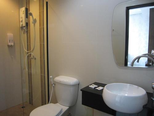 Un baño con inodoro, lavabo y ducha. en Krabi River View Hotel, en Krabi