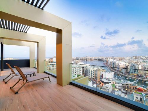 a balcony with a chair and a view of a city at Mercure St. Julian's Malta in St Julian's