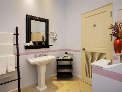 
a bathroom with a sink, toilet and mirror at La Veranda Resort Phu Quoc - MGallery in Phú Quốc
