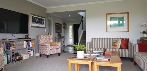 a living room with a couch and a table at RIDGETON in Aongatete
