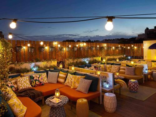a rooftop patio with couches and lights at night at Mama Shelter Paris East in Paris