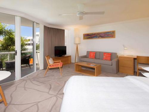 a hotel room with a bed and a couch at Sofitel Noosa Pacific Resort in Noosa Heads