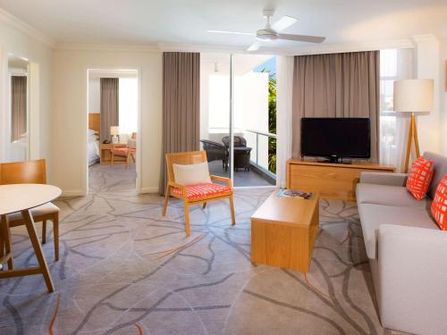 a living room with a couch and a tv at Sofitel Noosa Pacific Resort in Noosa Heads