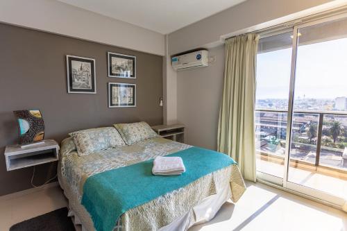 a bedroom with a bed and a large window at Departamento Tucuman in San Miguel de Tucumán