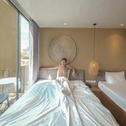 a man laying on a bed in a bedroom at Cagina Boutique Hostel in Dong Hoi