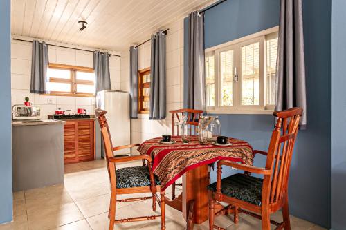 cocina con mesa y 2 sillas y cocina con paredes azules en Vintage Apartments Florianópolis, en Florianópolis
