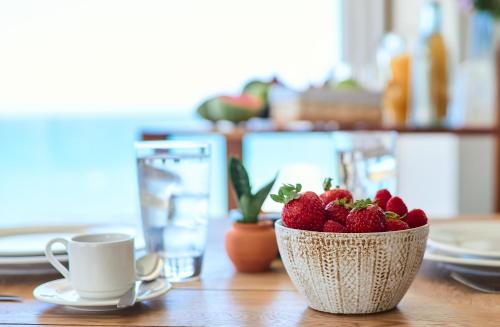 a bowl of strawberries sitting on a wooden table at Hotel Basalto in Punta Mita