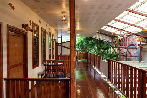 a corridor of a building with tables and chairs at Baan Kitsada in Amphawa