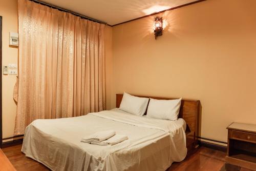 a bedroom with a bed with two towels on it at Baan Kitsada in Amphawa