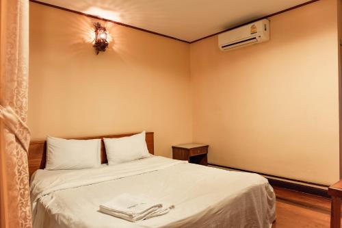 a bedroom with a bed with two towels on it at Baan Kitsada in Amphawa