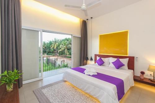 a bedroom with a large bed and a large window at Phan NaTa Apartment in Siem Reap