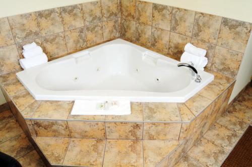 a large white bath tub in a bathroom at Trend Mountain Hotel & Conference Centre in Tumbler Ridge