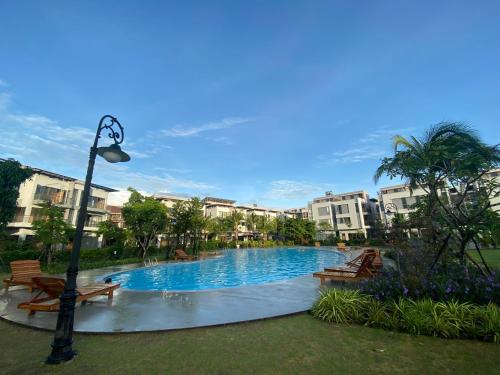 a swimming pool in a park with benches and buildings at Luna Oriental in Phu Quoc