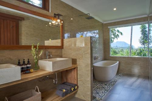 uma casa de banho com 2 lavatórios e uma banheira. em Palmterrace em Culik