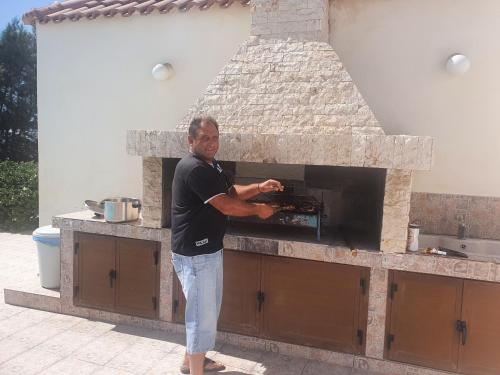 um homem parado em frente a um forno de pedra em Mansion 12 em Larnaka