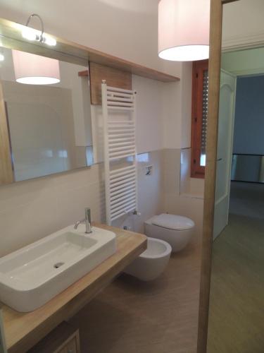 a bathroom with a sink and a toilet and a mirror at Camera con Vista in Oristano