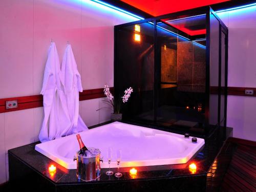 a bathroom with a large tub with lights in it at Motel Sunset (Adult Only) in Belo Horizonte