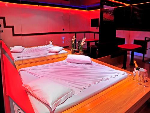 duas camas num quarto com paredes vermelhas em Motel Sunset (Adult Only) em Belo Horizonte