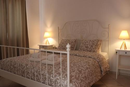 a bedroom with a white bed with two lamps at Baou House in Metsovo