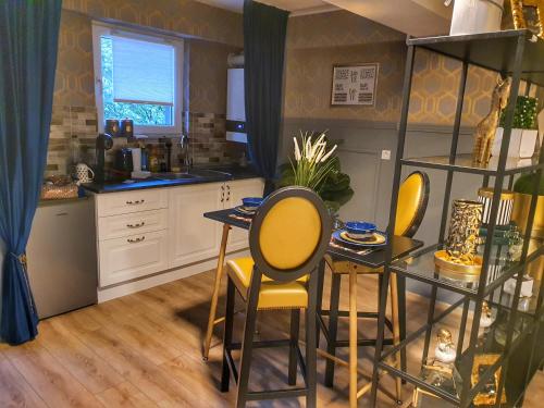 uma cozinha com uma mesa e cadeiras amarelas num quarto em Portobella Airport Aparthotel - Self Check in em Otopeni