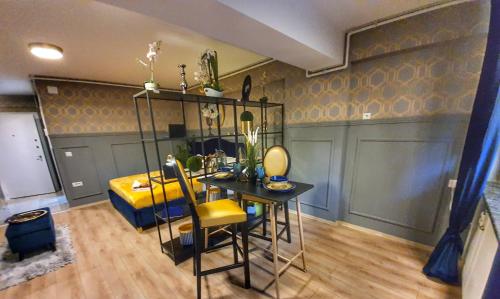 a dining room with a table and a yellow chair at Portobella Airport Aparthotel - Self Check in in Otopeni