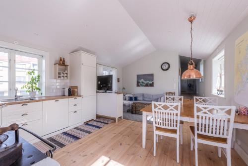 a kitchen and dining room with a table and chairs at Small Red House In Central Vaxholm in Vaxholm