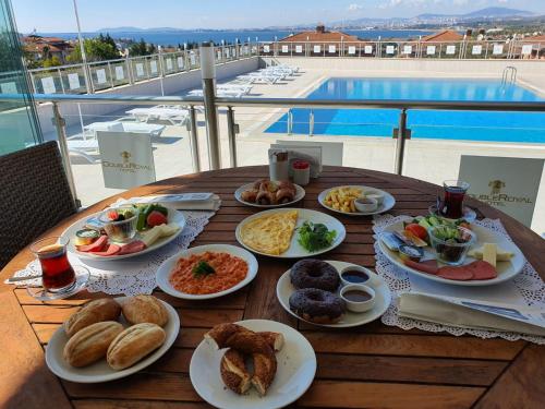 a wooden table with plates of food on it at DOUBLE ROYAL HOTEL in Kocaeli