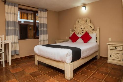 1 dormitorio con 1 cama grande con almohadas rojas en Hotel Rincon Soñado, Valle de Bravo en Valle de Bravo