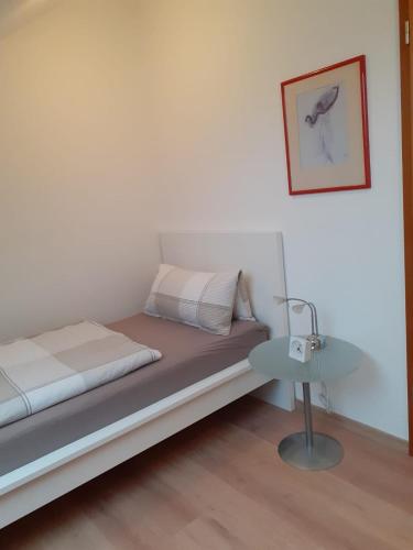 a bedroom with a bed with a lamp and a table at Ferienwohnung Rheinzabern in Rheinzabern