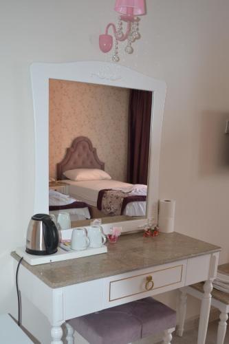 a mirror on top of a dresser in a bedroom at Turk Hotel in Oludeniz